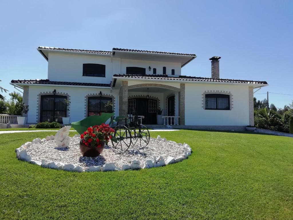 ein Haus mit einem Brunnen im Vorgarten in der Unterkunft Casa do Vale in Leiria