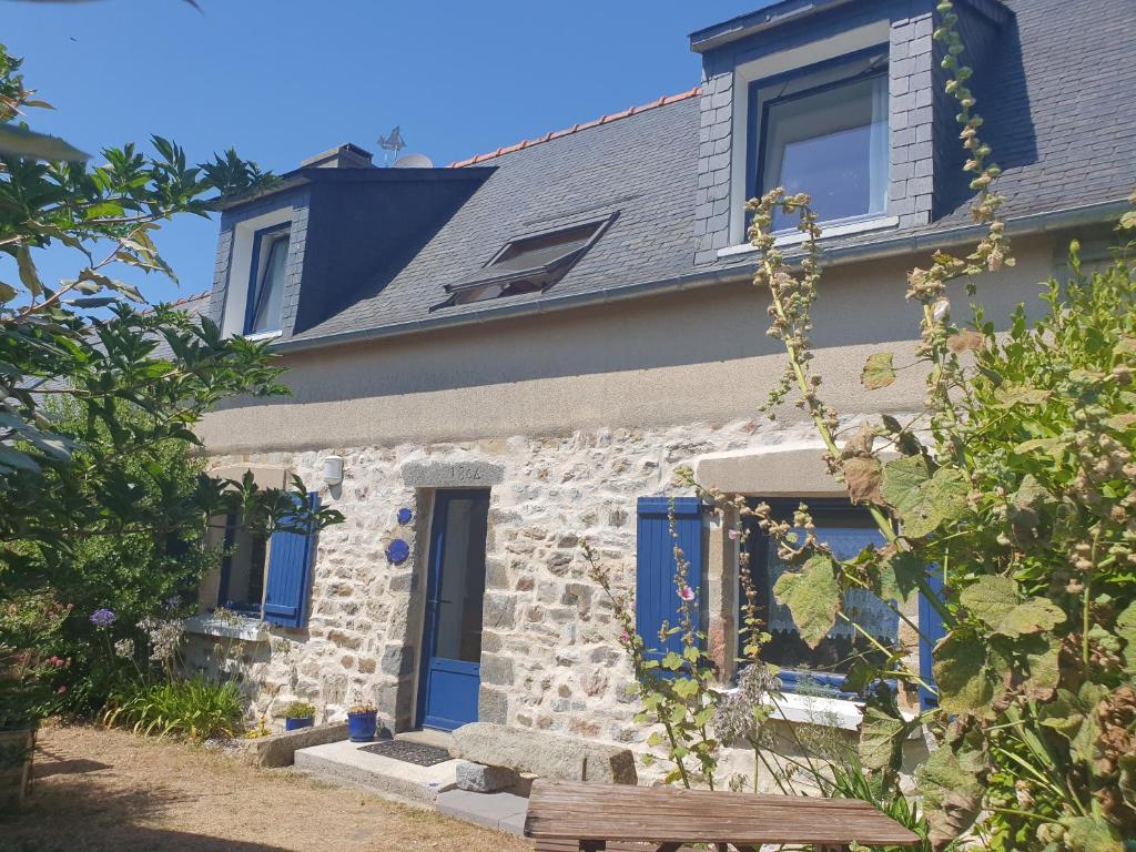 a stone house with blue doors and a bench at Maison typique bretonne a 5 min de la plage a pied in Crozon