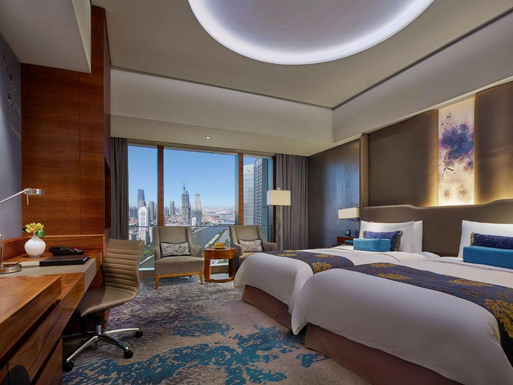 Una cama o camas en una habitación de Shangri-La Tianjin