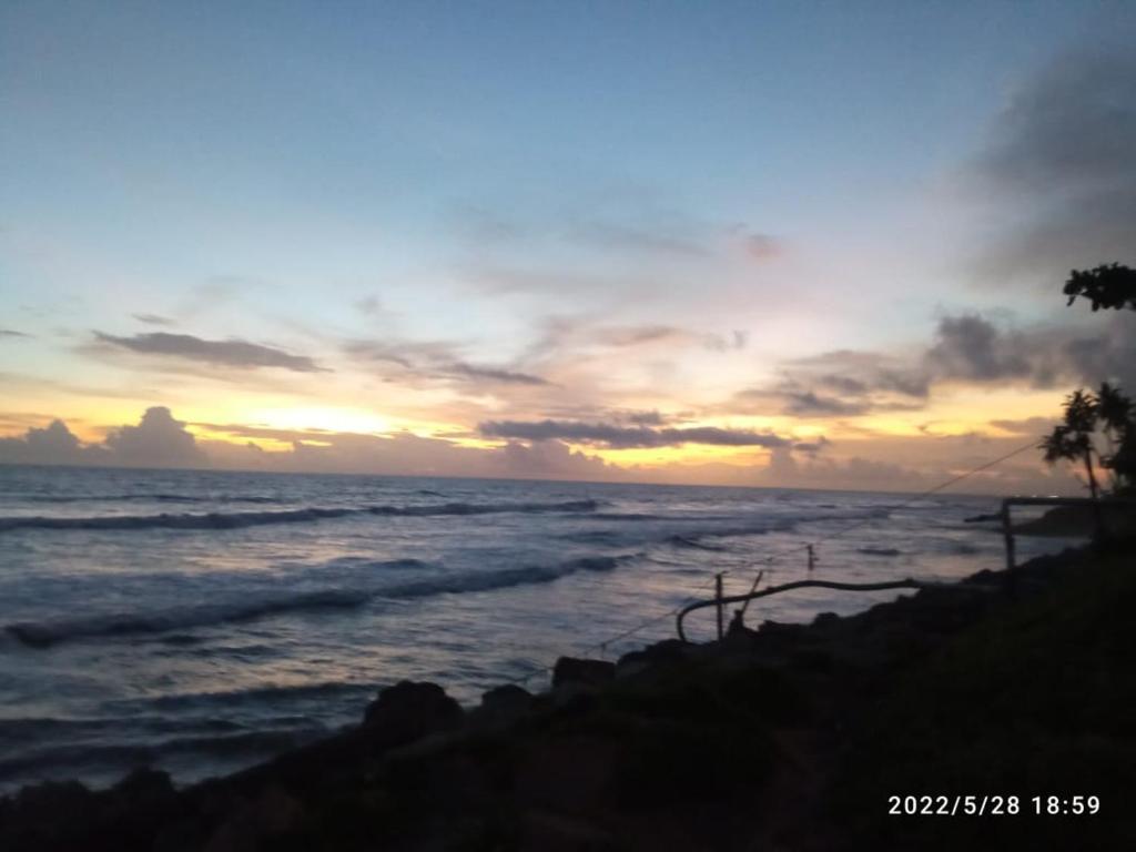 een zonsondergang boven de oceaan met de oceaan bij Devi Kripa Residency in Varkala