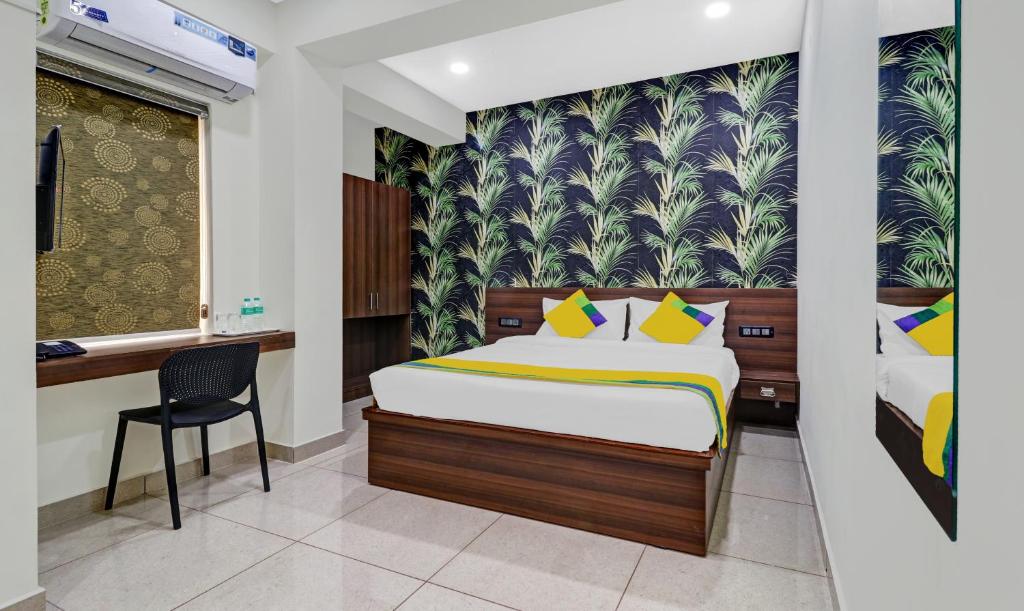 a bedroom with a bed and a chair in a room at Itsy Hotels NRM Residency in Mysore