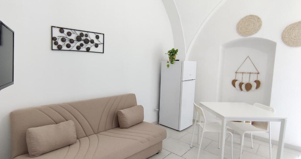 een witte woonkamer met een bank en een tafel bij Appartamenti Boho Chic in Sannicandro di Bari