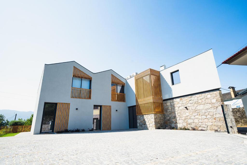 una casa bianca con finestre in legno e vialetto di Casa João Eusébio 3 a Ponte de Lima