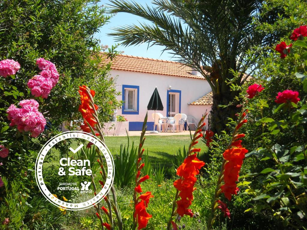 um jardim com uma casa ao fundo com flores em Monte Da Serralheira Agro Turismo em Évora