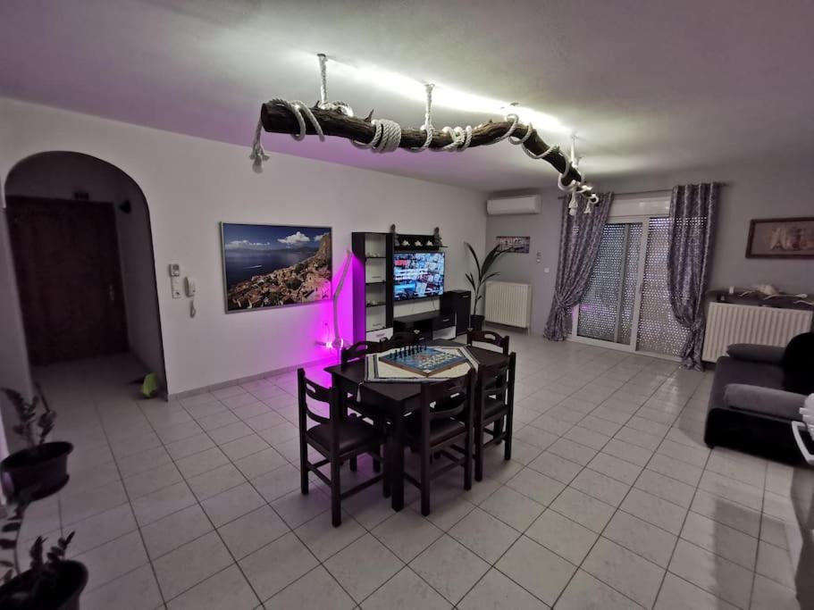 a living room with a table and chairs with pink lights at Elli's House in Keramotí