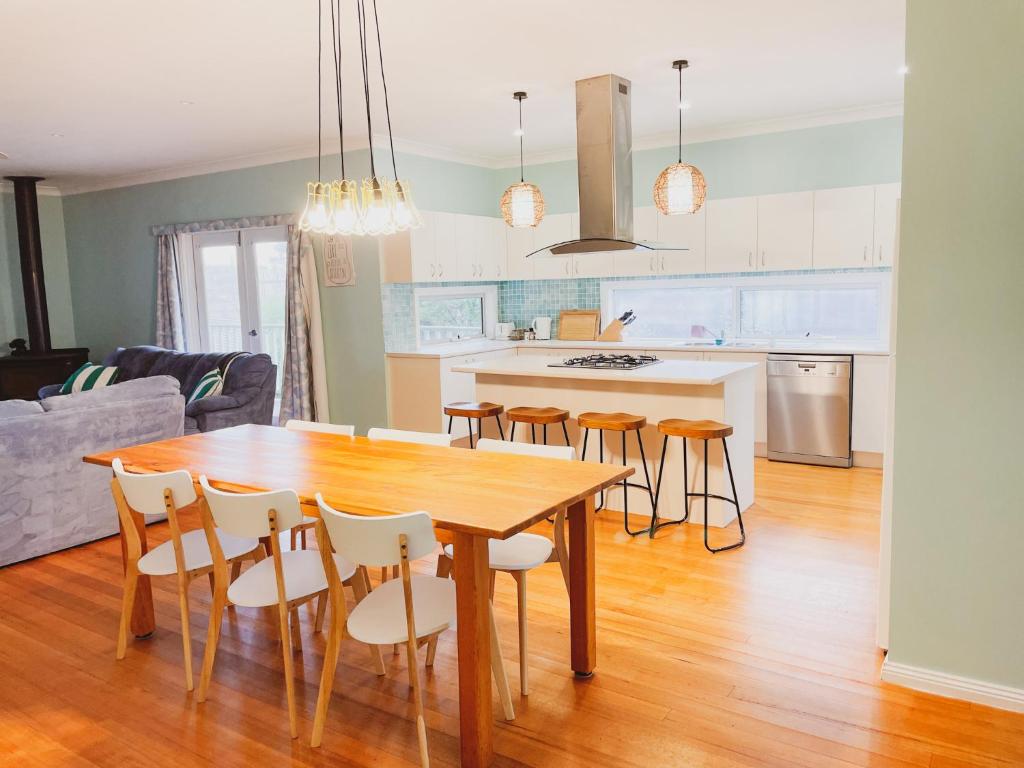 cocina y comedor con mesa de madera y sillas en Seabatical Port Campbell, en Port Campbell