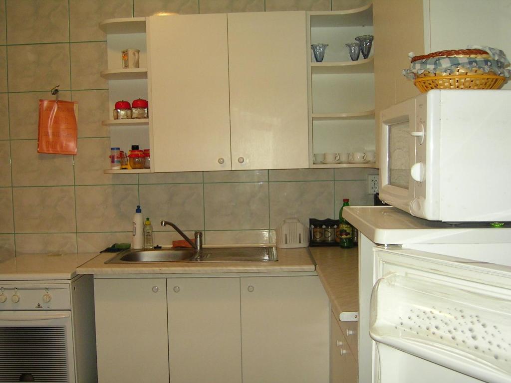 a kitchen with a sink and a microwave at Szigeti B&B in Bogács