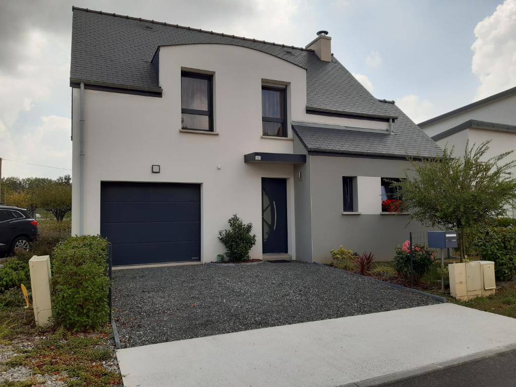 a white house with a garage at Kerlann Bruz in Bruz