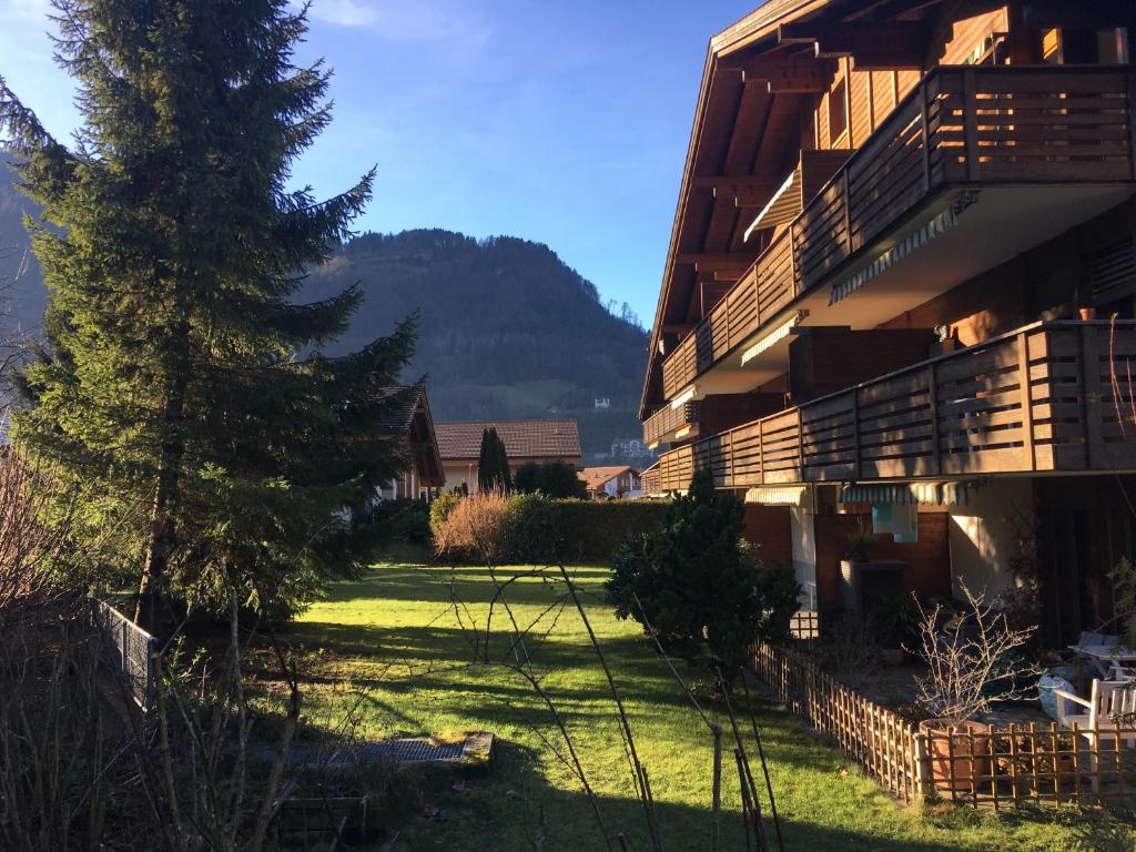 ein Gebäude mit einem Baum und einer Kirche im Hintergrund in der Unterkunft Ferienwohnung Interlaken/Wilderswil in Wilderswil