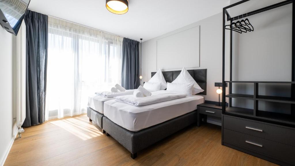 - une chambre avec 2 lits et une grande fenêtre dans l'établissement Hotel Metropol, à Tübingen