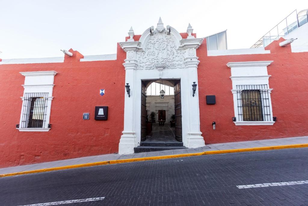 un edificio rojo con una puerta blanca en una calle en Casa Andina Premium Arequipa, en Arequipa