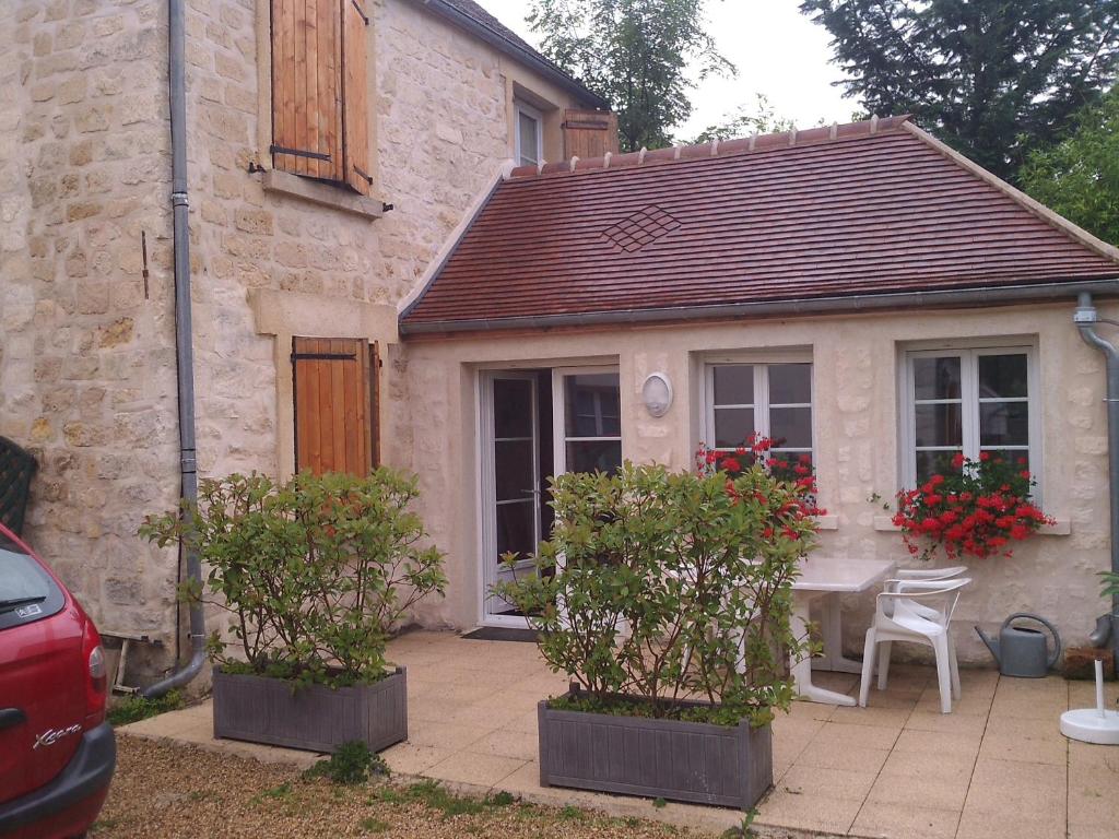 a house with a table and chairs in front of it at Gîte Les Rainettes in Coye-la-Forêt