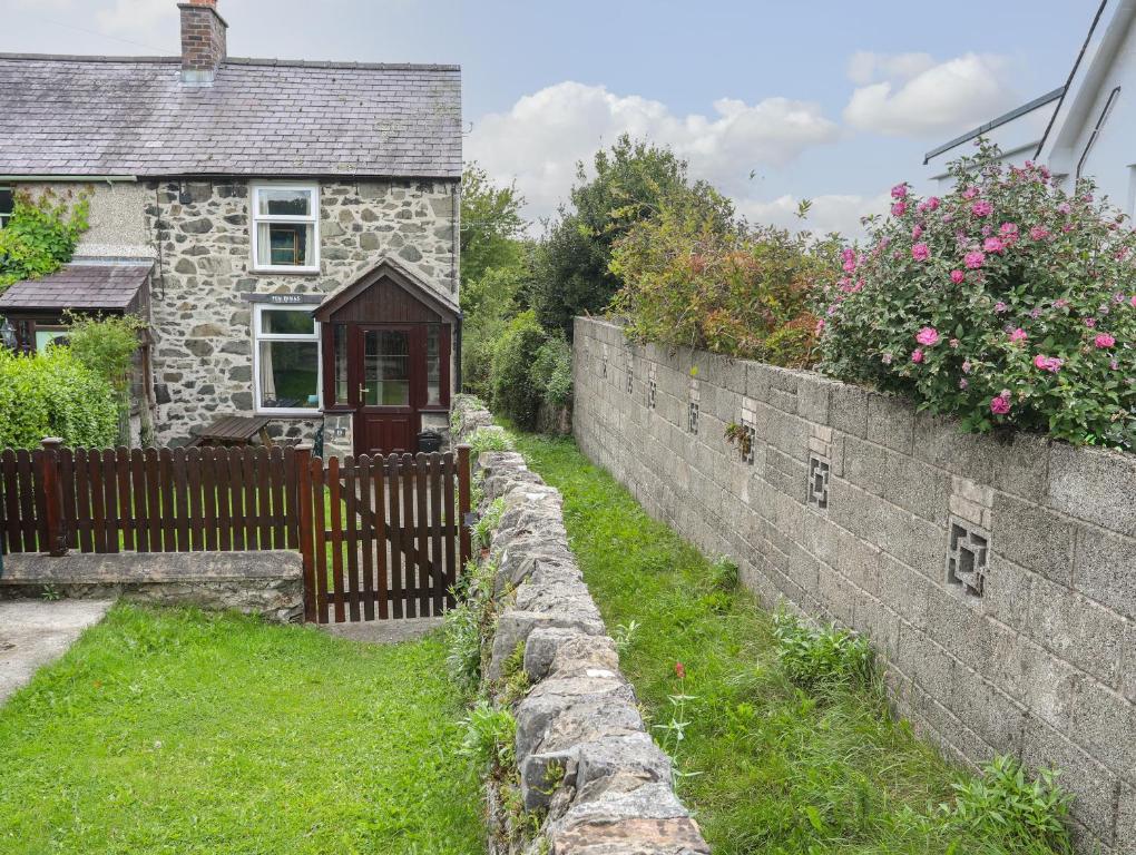 a stone retaining wall in front of a house at Pen Dinas in Bangor