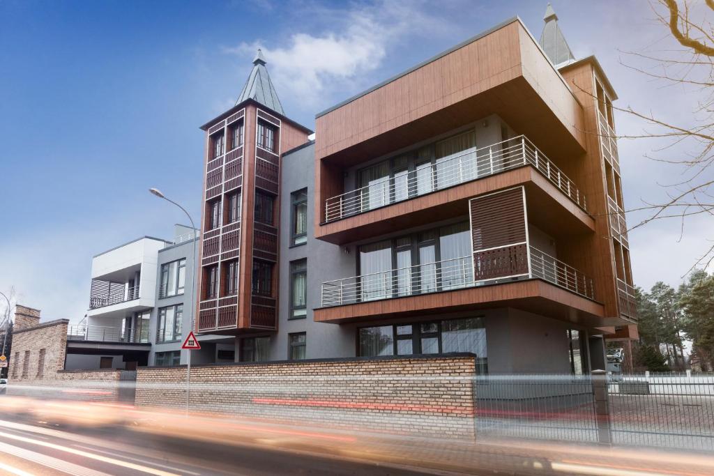 un bâtiment avec une tour d'horloge à côté d'une rue dans l'établissement Sonia Apartments, à Jurmala