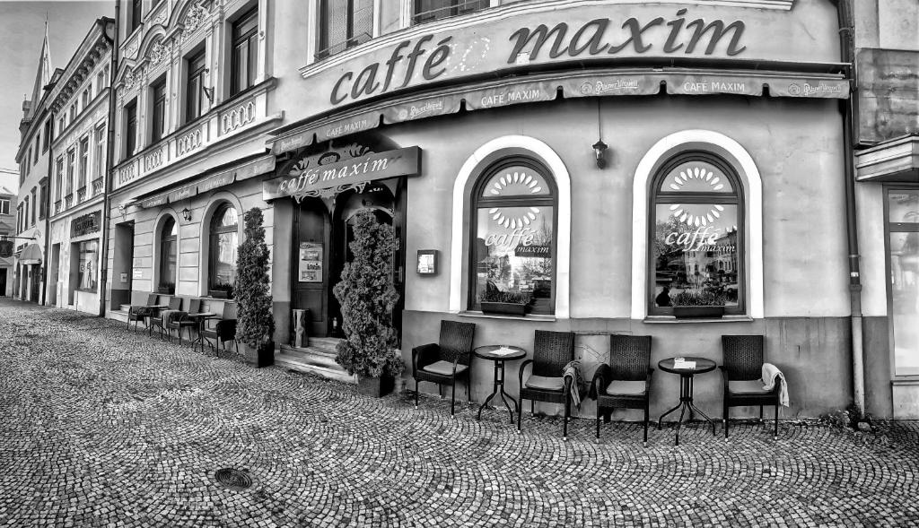 a coffee shop with chairs and tables on a street at Hotel Maxim in Frýdek-Místek