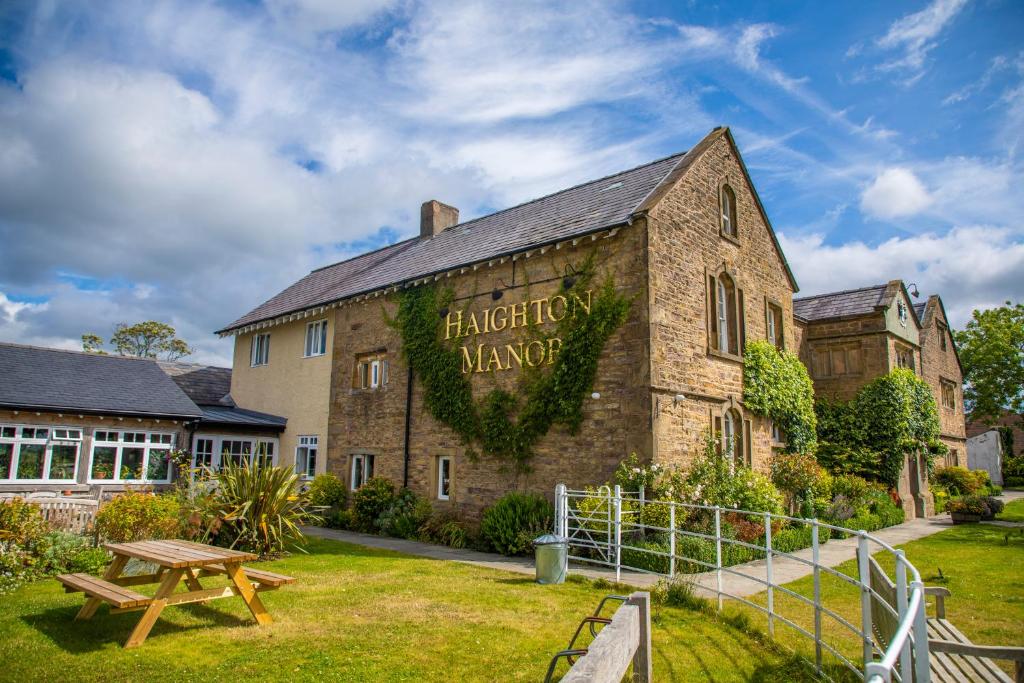 un bâtiment avec un panneau sur son côté dans l'établissement Haighton Manor - Brunning and Price, à Grimsargh