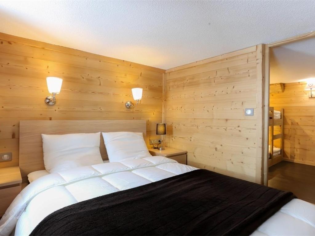 Schlafzimmer mit einem großen weißen Bett und Holzwänden in der Unterkunft Duplex rénové à Val Thorens, 3 chambres, 6 pers, proche pistes et commerces - FR-1-637-49 in Val Thorens