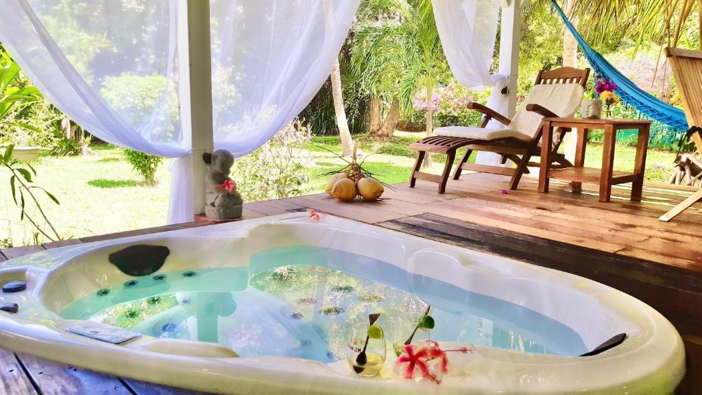 een bad in het midden van een patio bij Villa Gaïa - Bungalow Ti-Zen et son jacuzzi niché dans un jardin tropical, séjour en amoureux in Le Diamant