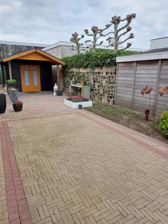 a patio with a building and flowers in a yard at De Poldersteeg 