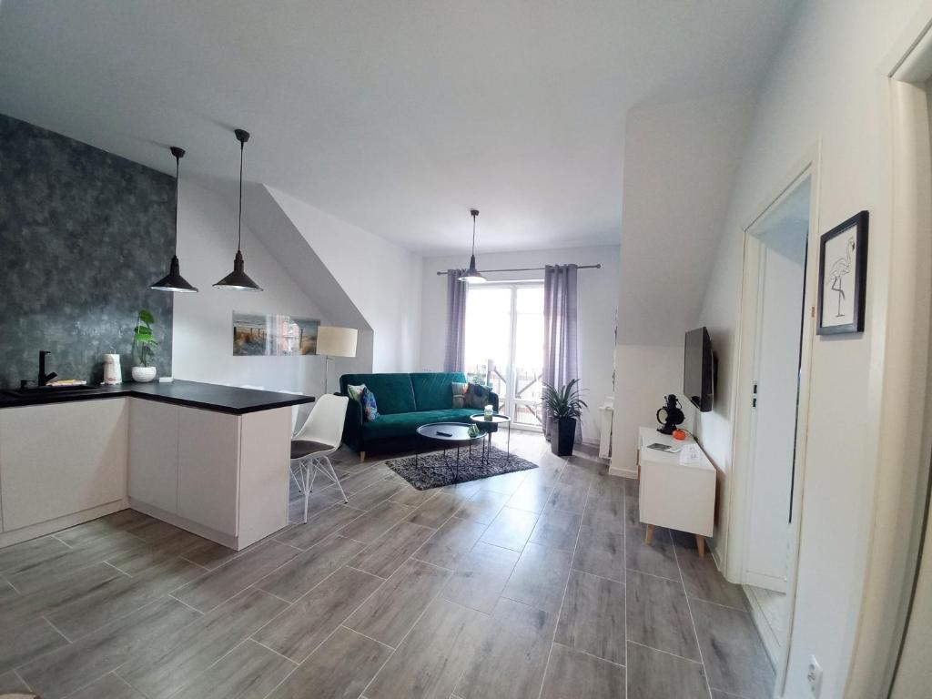 sala de estar con cocina y sala de estar con sofá en Apartament nad Jeziorem, en Olecko