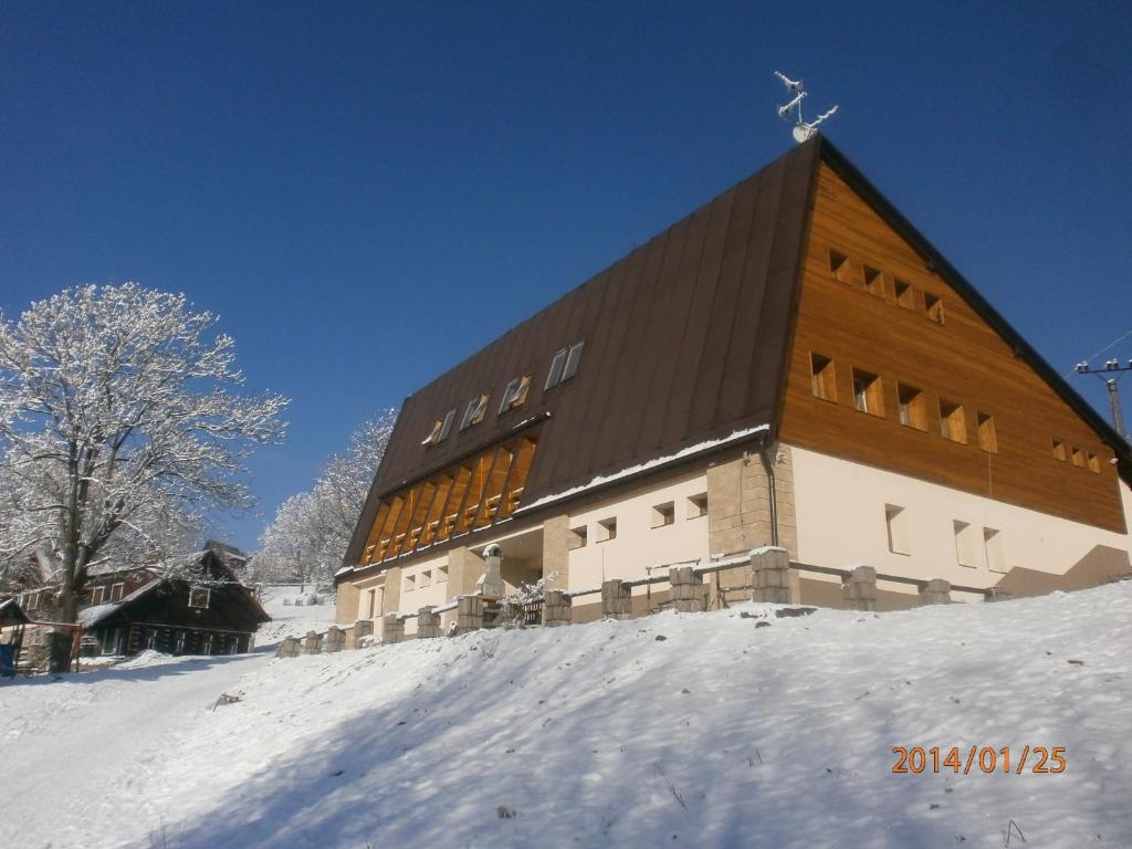 ストラージュネーにあるHotel Vltavaの雪面の上の大きな建物