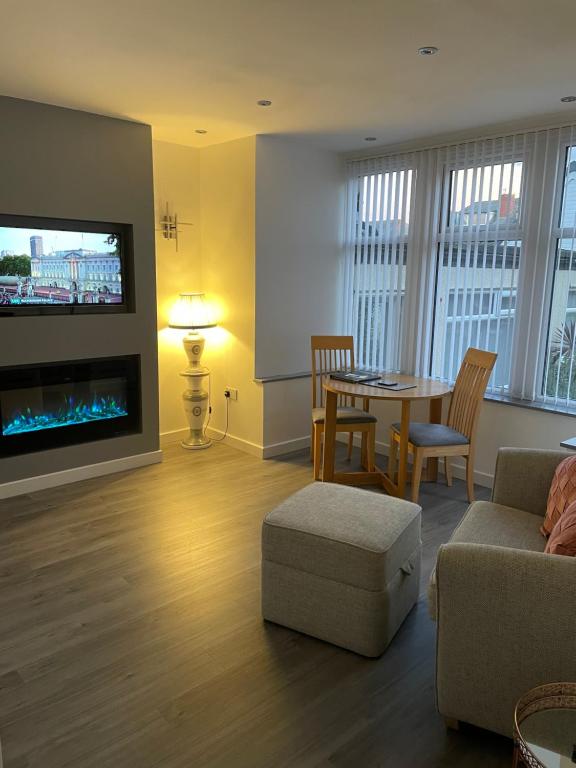 un soggiorno con divano, tavolo e TV di San Remo Apartments Blackpool a Blackpool