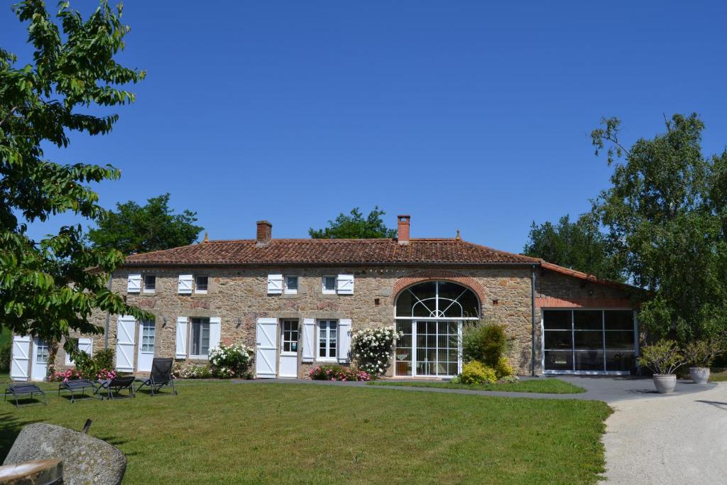 una grande casa in mattoni con un prato di fronte di Logis de La Bénétière a Treize-Vents