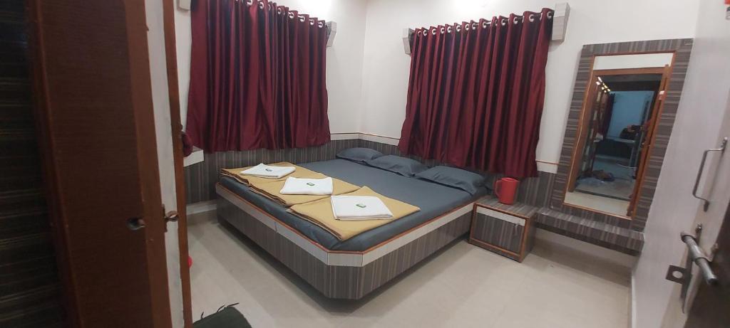 una piccola camera con letto e specchio di Sai Raghunandan Guest House a Shirdi