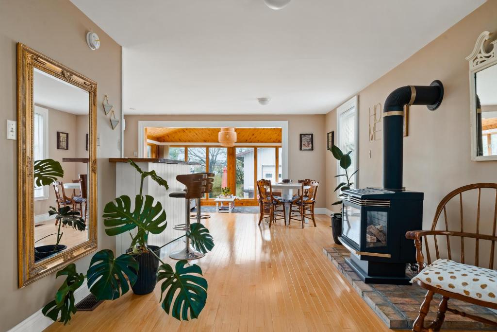 a living room with a wood stove and a dining room at Sunroom on Maple in Picton