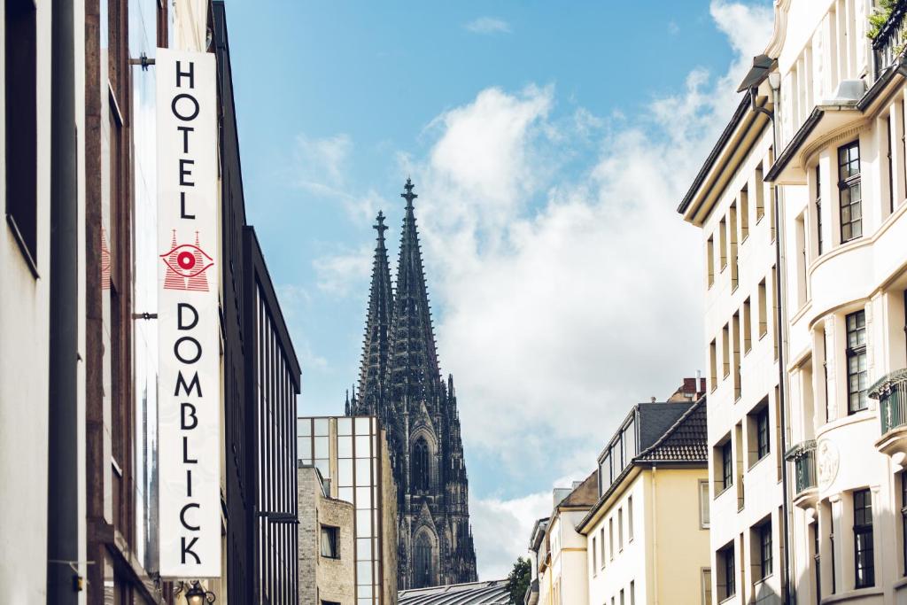 een kerktoren op de achtergrond van een stad bij Hotel Domblick Garni in Keulen