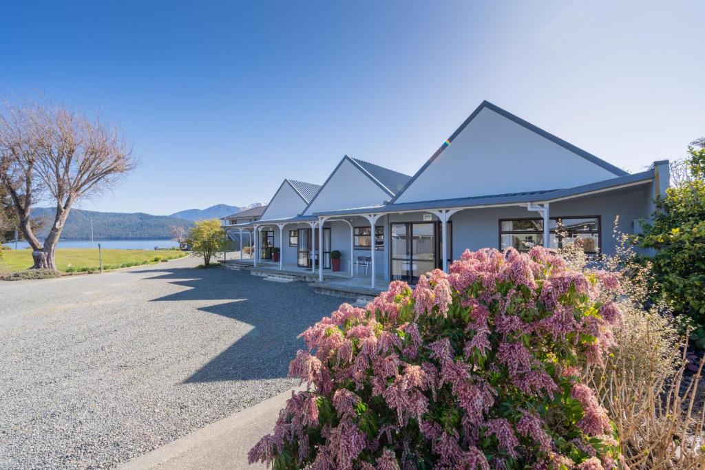 una casa con fiori viola sul ciglio di una strada di Te Anau Motel & Apartments a Te Anau