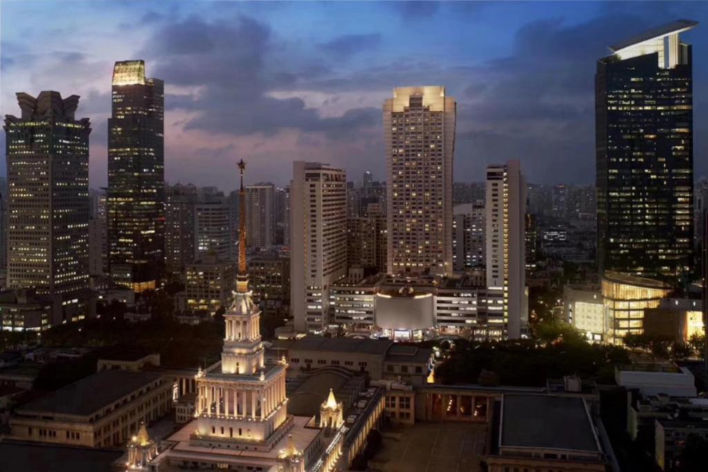 uma vista para o horizonte da cidade à noite em Shanghai Centre Serviced Apartment em Xangai