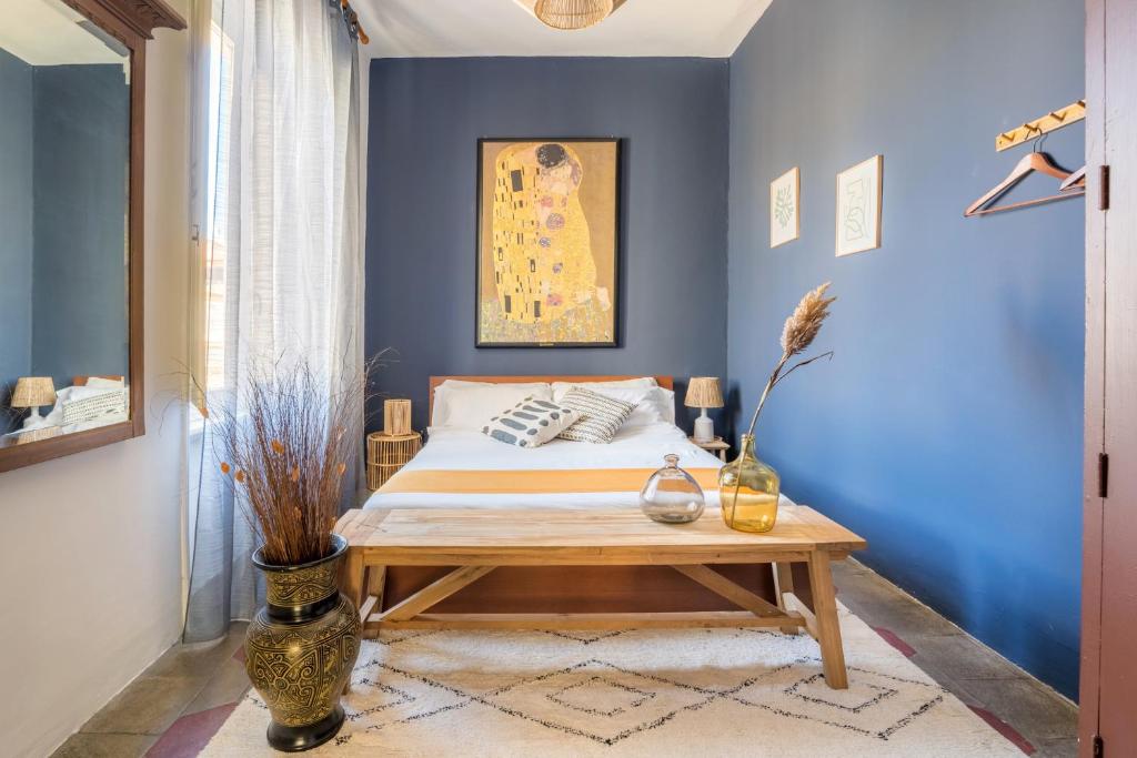 een slaapkamer met blauwe muren en een bed met een houten tafel bij Bohome Suite - Ethnic Apt in the Center of Rome in Rome