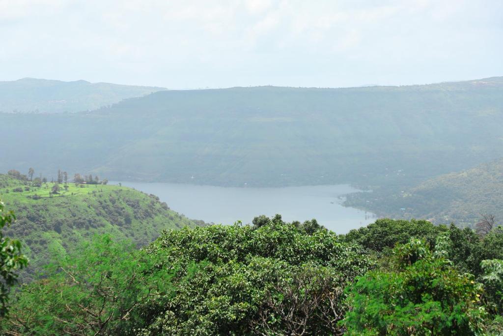 uitzicht op een meer op een heuvel met bomen bij X Western Hills panchagani in Panchgani