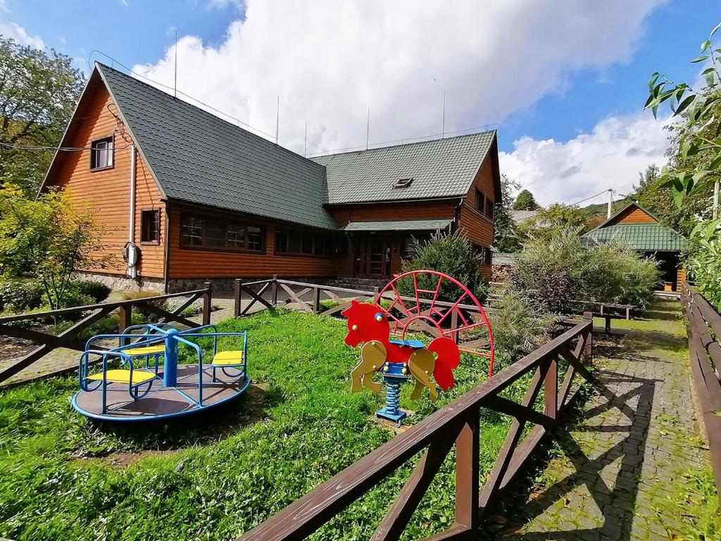 dois equipamentos de recreio em frente a uma casa de madeira em Shale Verba em Kvasir