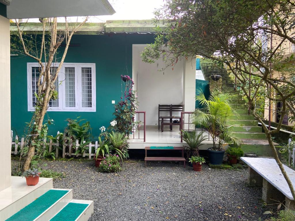 a blue and white house with a bench and plants at Ammus Homestay in Thekkady