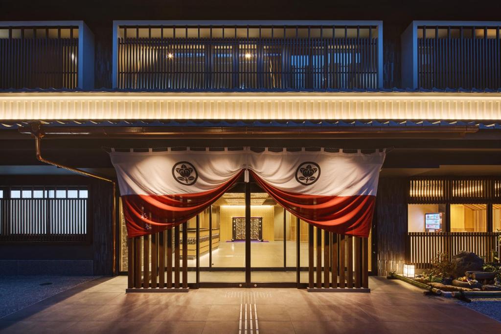 un accès à un bâtiment avec un rideau rouge blanc et bleu dans l'établissement Hotel Sugicho, à Kyoto