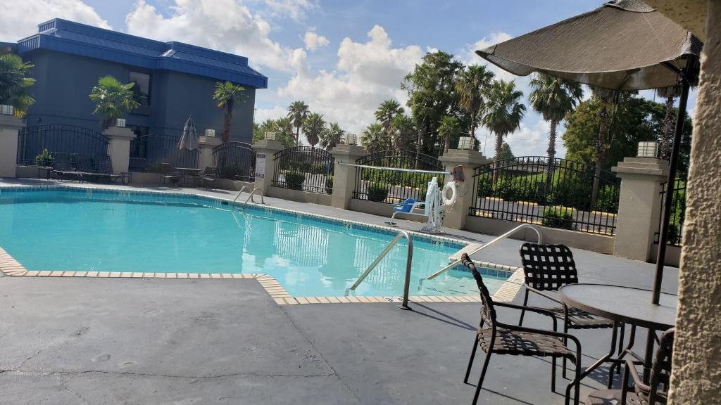 una piscina en un hotel con mesa y sillas en Red Roof Inn Port Allen, en Port Allen