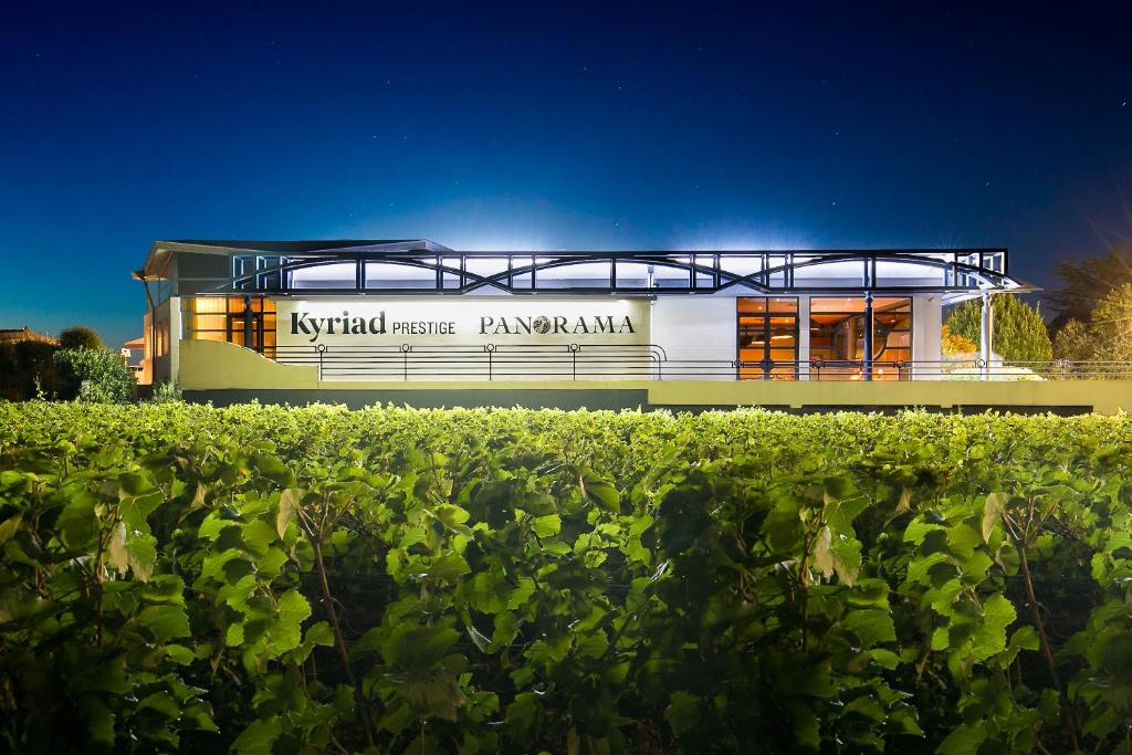 um edifício em frente a um campo de culturas em Kyriad Prestige Beaune le Panorama em Beaune