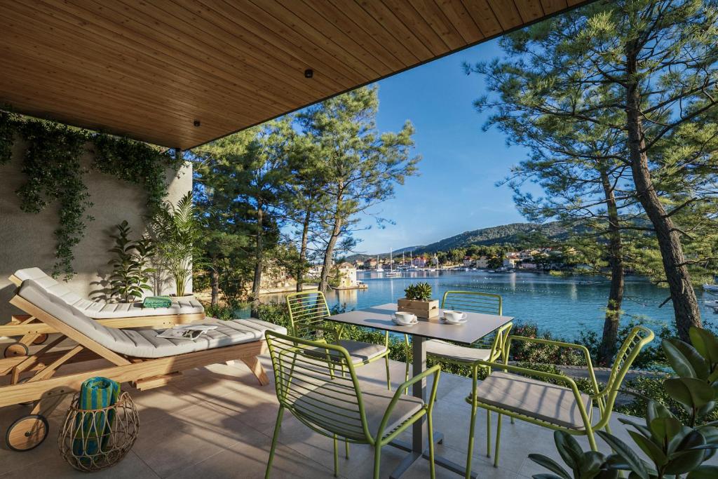 a patio with a table and chairs and a view of the water at Valamar Amicor Resort in Stari Grad