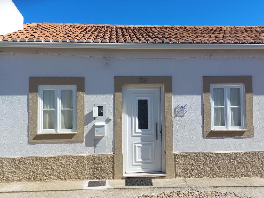 uma casa branca com duas janelas e uma porta em Casa do Tio Zé na Golegã