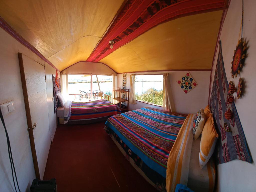 Kleines Zimmer mit einem Bett und einem Tisch in der Unterkunft Uros Titicaca Khantaniwa Lodge in Puno