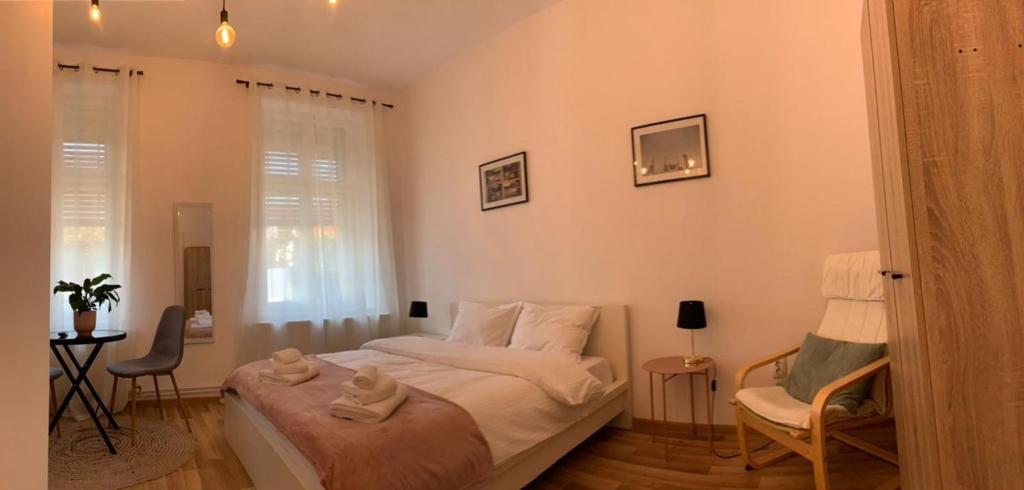 um pequeno quarto com uma cama e uma cadeira em Apartament Plopilor Studios em Sibiu