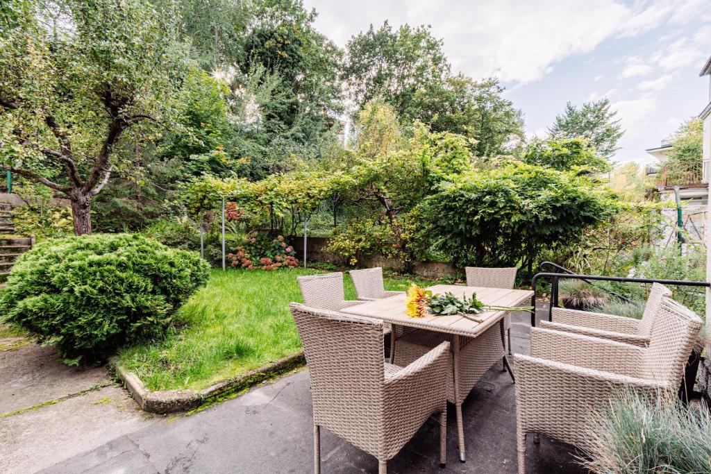 eine Terrasse mit Korbstühlen und einem Tisch in der Unterkunft Beach House Escape in Gdynia