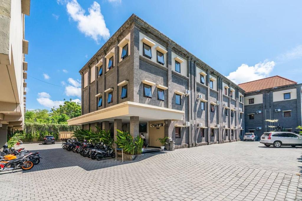 a building with motorcycles parked in front of it at Ganandra Stay Denpasar in Denpasar