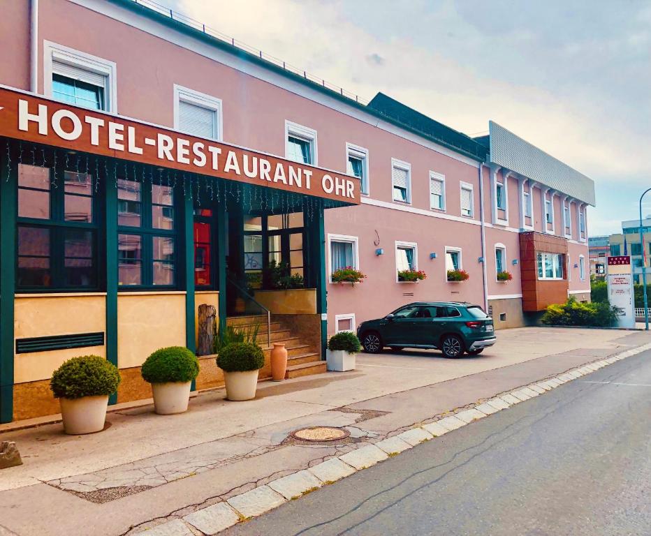 un coche aparcado frente a un restaurante del hotel en Gasthof OHR, en Eisenstadt