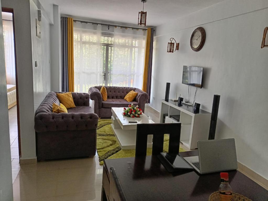 ein Wohnzimmer mit 2 Sofas und einem Tisch in der Unterkunft Zoe Homes Greypoint 1br and 2br Apartment 101 in Kericho