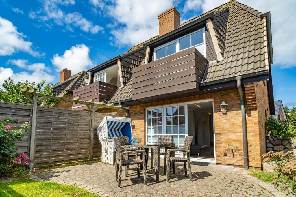 une maison avec une table et des chaises devant elle dans l'établissement Haus Strandoase, à Westerland