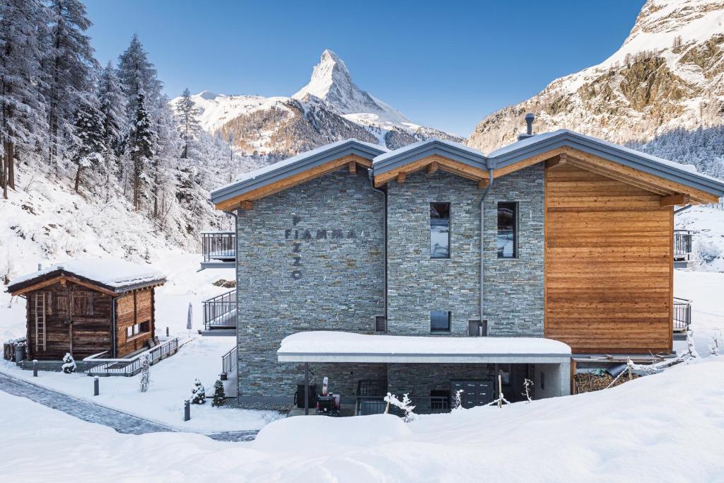 domek narciarski na śniegu z górami w tle w obiekcie Apartment in Chalet Pizzo Fiamma w mieście Zermatt