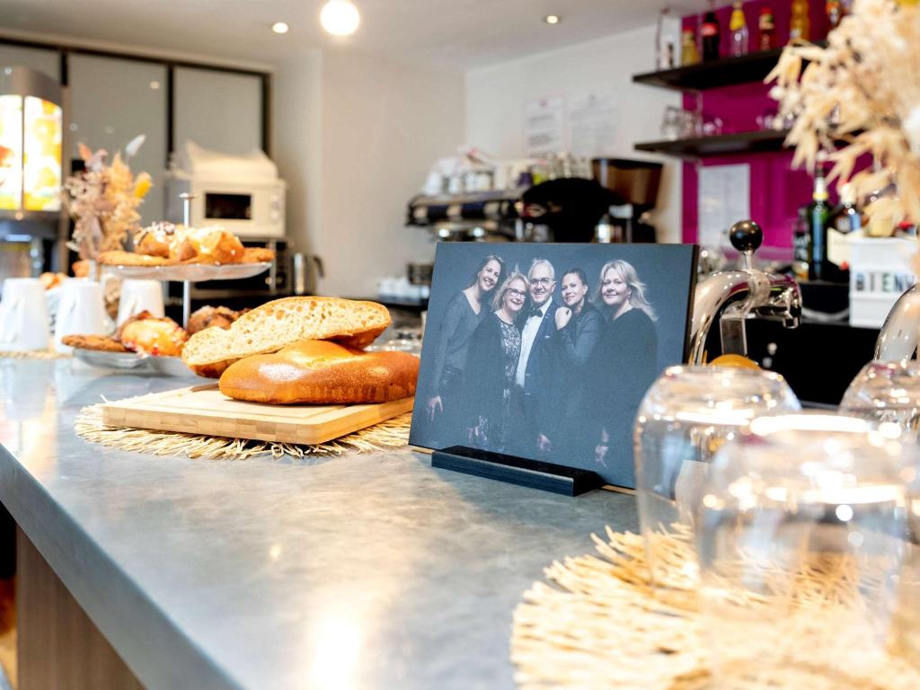 un mostrador con pan y una foto de las cuatro monjas en ibis Styles Rennes St. Gregoire, en Saint-Grégoire